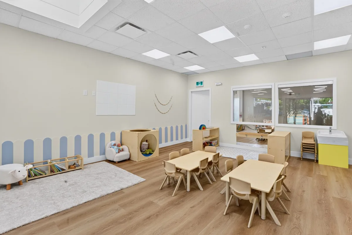 Bright MIM classroom with low tables, a reading rug and soft seating