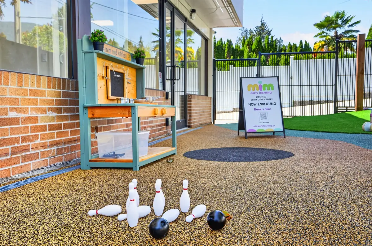 Toddler bowling set and mud kitchen on the soft outdoor surface