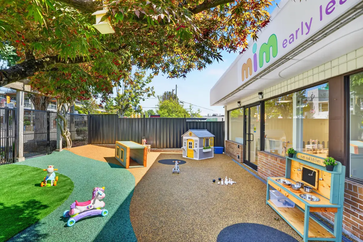 Outdoor yard beside the MIM building with the mim early learning sign